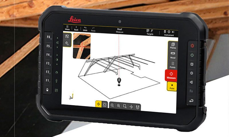 Software Leica iCON trades per la Finitura d'Interni su un tablet nero Leica iCON davanti a un cantiere adibito alla costruzione di un tetto in legno isolato.